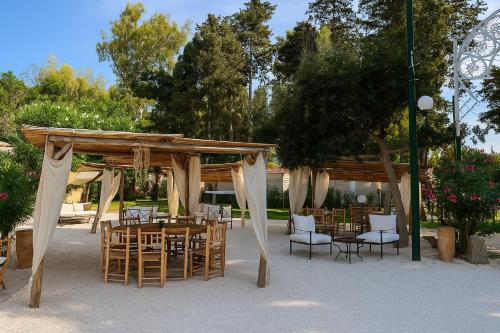 een tafel en stoelen onder een houten paviljoen bij Hotiday Otranto Porto in Otranto