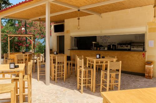 een restaurant met houten tafels en stoelen en een bar bij Hotiday Otranto Porto in Otranto