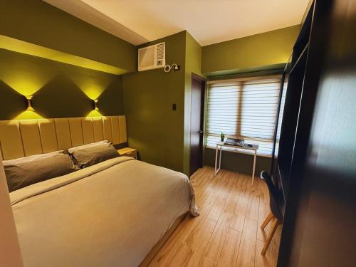 GM City Rentals في مانداوي سيتي: غرفة نوم بسرير ونافذة وطاولة