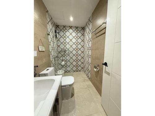 GM City Rentals في مانداوي سيتي: حمام مع مرحاض أبيض ومغسلة