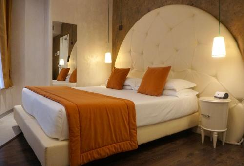 a bedroom with a large bed with an orange blanket at Hotel Vespasiano in Rome
