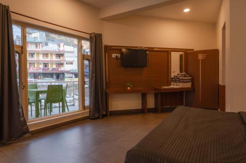 a room with a bed and a window with a balcony at Hotel Morainic Hills Mall Road Bhagsunag in McLeod Ganj