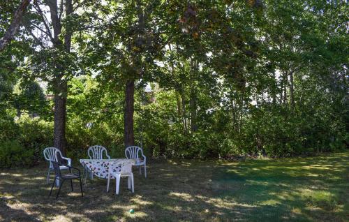 a table and chairs in a yard with trees at 1 Bedroom Amazing Apartment In Hultsfred in Hultsfred