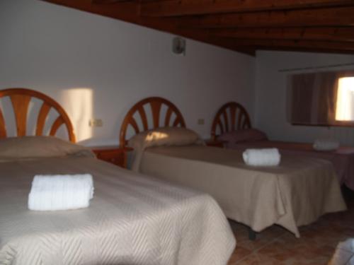 a hotel room with three beds and a window at Apartamento2 San Cristobal cerca de Cuenca in Colliguilla