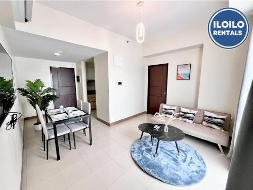 Luxury 1-Bedroom Stay at Saint Honore في Mandurriao: غرفة معيشة بها أريكة وطاولة