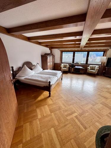 a bedroom with a bed in a room with wooden floors at Bed & Breakfast Schäfer in Enzklösterle