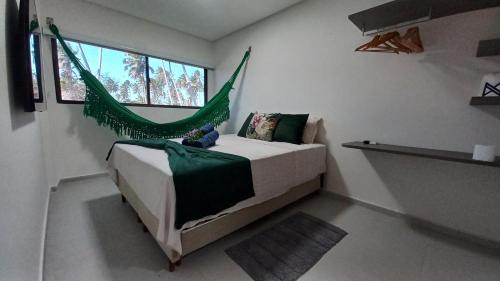a bedroom with a bed with a hammock in it at Apto Pe na Areia com Piscina Privativa in Ipioca