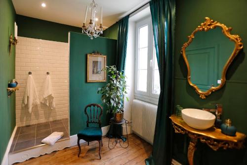 a bathroom with green walls and a sink and a mirror at Villa La Poste 