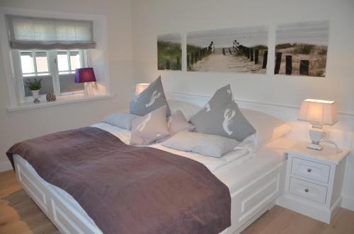a white bed with pillows on it in a bedroom at LITZKOW 15005 in Morsum