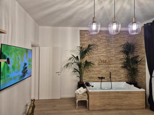 a bathroom with a tub and two potted plants at Superior Suite, Villa Joy Verona, Luxury Romantic Suite with Jacuzzi, near City Center in Verona