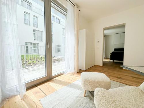 REAL Living by REFA - Modern Haven 1311 في Golčŭv Jeníkov: غرفة معيشة مع كرسي ونافذة كبيرة