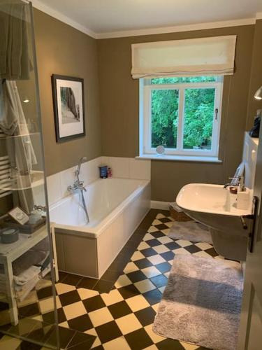 a bathroom with a bath tub and a sink at EinfachSein Zimmer in Trittau