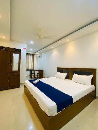 a bedroom with a large bed in a room at Metro Residency in Perintalmanna