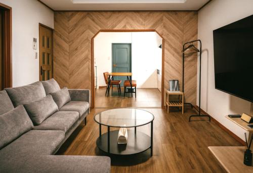 a living room with a couch and a table at 富山駅徒歩15分 環水公園徒歩8分 旅行拠点に最適 和モダン空間でゆったり滞在 in Toyama