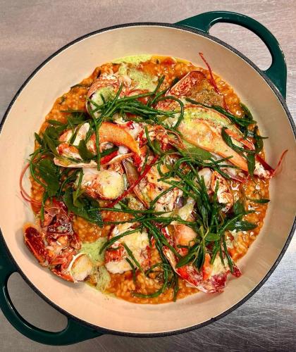 a pizza with shrimp and vegetables in a pan at The Ship in Brancaster
