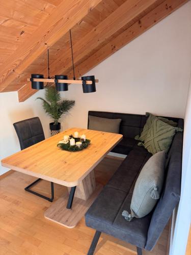 a dining room with a wooden table and a couch at Ferienwohnung Alpenglühen in Sonthofen