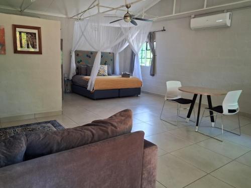 Acacia Cottage في ماون: غرفة معيشة بها أريكة وسرير وطاولة