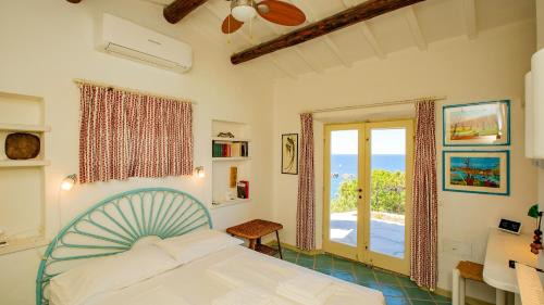 a bedroom with a bed and a view of the ocean at Futura anima sarda, villa sul tramonto con piscina privata in Costa Paradiso