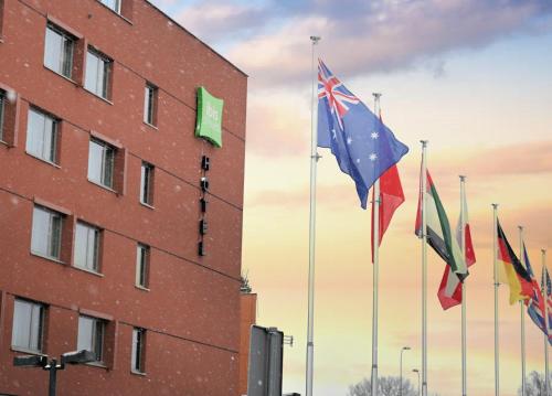 a group of flags flying in front of a building at ibis Styles Warszawa Airport in Warsaw