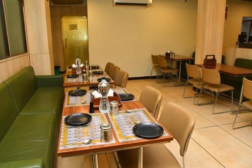 a dining room with tables and chairs in a restaurant at Raj Gharana in Raipur
