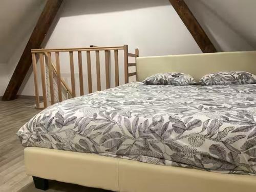 a bedroom with a bed with a bedspread with leaves at ღ Le Nid Douai - T2 Proche Centre Ville & Gare in Douai