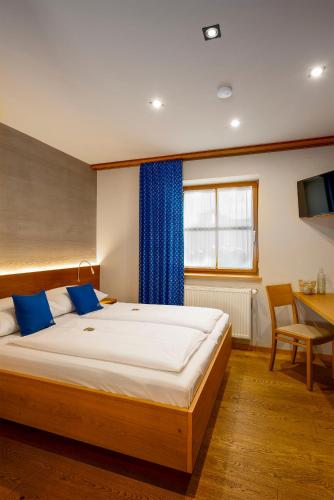 a bedroom with a large bed with blue pillows at Winzerhof Kiss in Jois