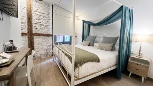 a bedroom with a canopy bed with a desk at Pensión Lo Bilbao in Bilbao