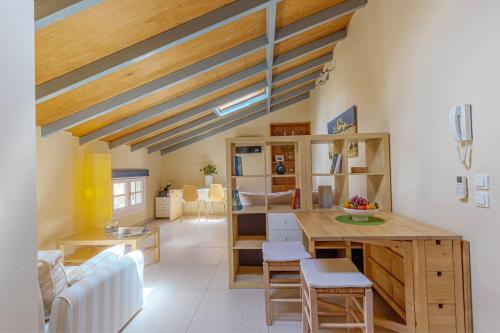 a living room with wooden ceilings and a table and chairs at Sunny Skylight Loft! in Ágios Rókkos