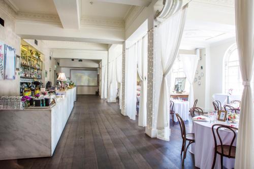 a restaurant with a long corridor with tables and chairs at Hotel Richmond on Rundle Mall in Adelaide