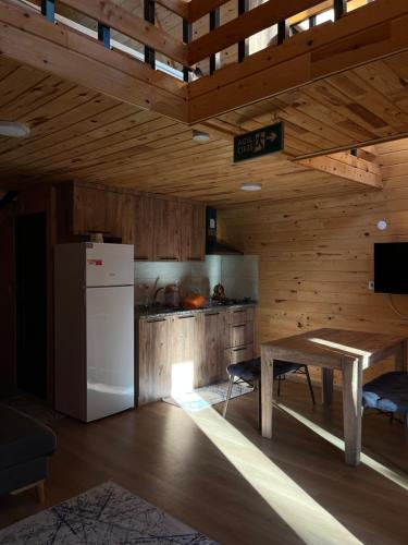 KumlucaにあるAdrasan Twin Apartsの白い冷蔵庫とテーブルのあるキッチン