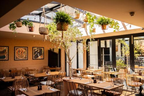 a restaurant with tables and chairs and potted plants at The Red Lion in Thames Ditton