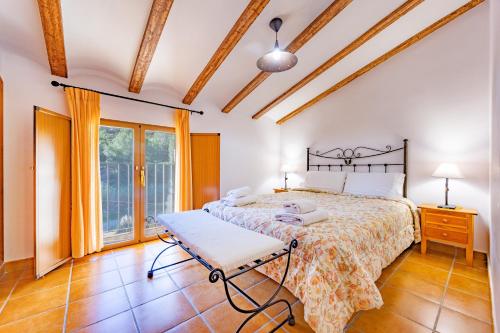 a bedroom with a bed and a window at El Molinet del Governador- Apartamentos Rurales in Guadalest