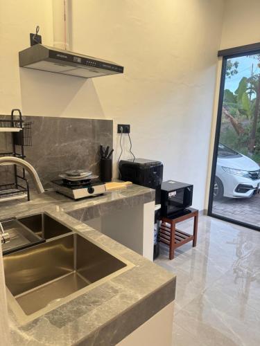 a kitchen with a sink and a counter top at Bayedan Homestay in Badung