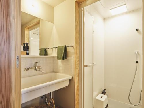 ein Badezimmer mit Waschbecken und Dusche in der Unterkunft TABiE in Izumo