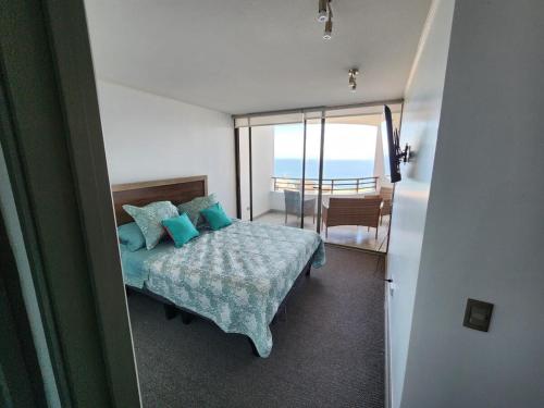 Un dormitorio con una cama con vista al mar. en Departamento 1 ambiente brisas del sur 2, en Iquique