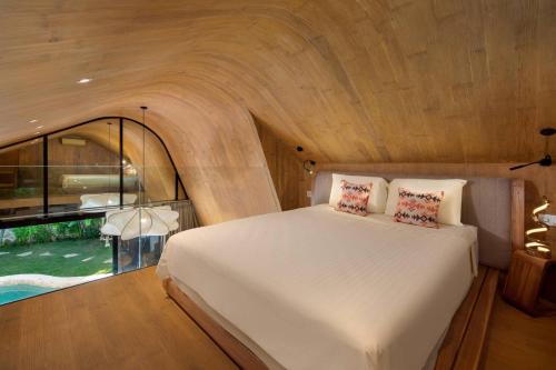 a bedroom with a bed and a large window at Cheria Eco Lodge in Selong Belanak