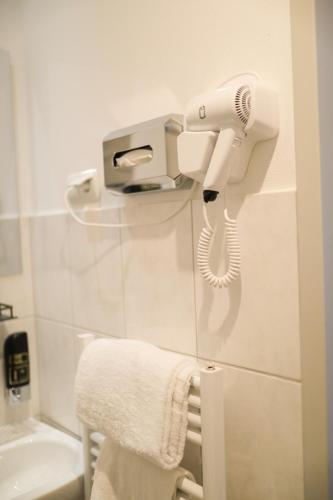 a bathroom with a hair dryer and a towel at Hotel Allee 55 in Hannover
