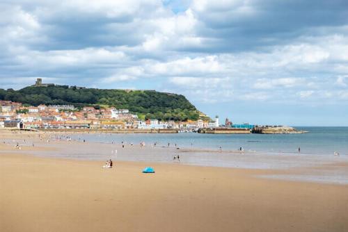 a group of people on a beach near the water at Bay View - Amazing Location dog friendly in Scarborough
