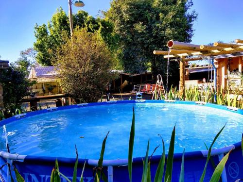 una gran piscina azul en medio de un patio en Hotel Pousada Casa Verde, en Cordisburgo