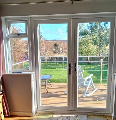 an open french door with a view of a patio at Countryside 2 Bed Bungalow with Stunning Views Free WiFi and Parking Ideal for Business and Leisure in Great Addington