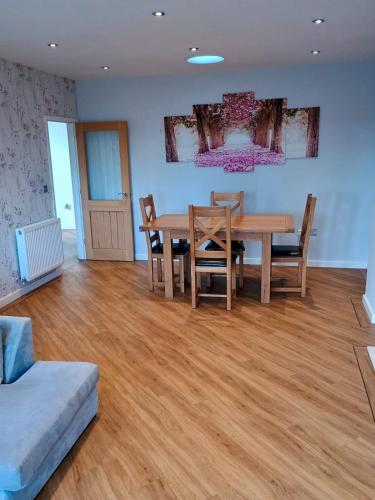 a dining room with a wooden table and chairs at Countryside 2 Bed Bungalow with Stunning Views Free WiFi and Parking Ideal for Business and Leisure in Great Addington