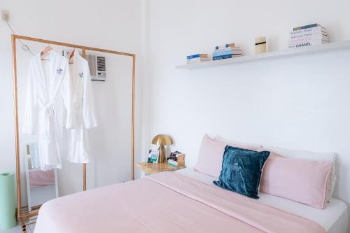 a white bedroom with a bed and a mirror at Bintana Sa Paraiso in Mambajao