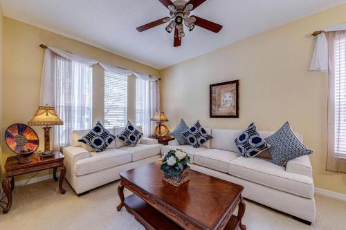 a living room with two couches and a ceiling fan at Watersong Sunbreeze Villa in Davenport