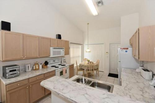 a kitchen with wooden cabinets and a white refrigerator at Rise & Shine! in Orlando