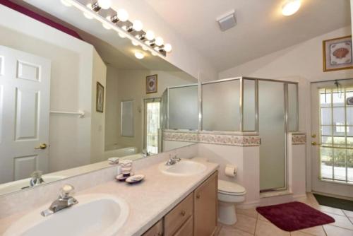 a bathroom with two sinks and a shower and a toilet at Rise & Shine! in Orlando