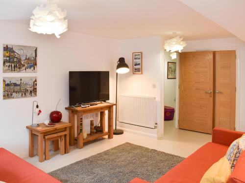 a living room with a flat screen tv on a wall at Potters Pad in Alnwick