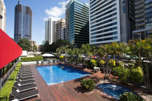 a swimming pool in a city with tall buildings at Royal On The Park in Brisbane