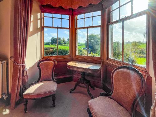 une chambre avec deux chaises, une table et une fenêtre dans l'établissement Kirkdale, à Kirkton