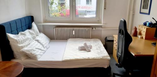 a small bedroom with a bed and a window at Tripplezimmer mit Garten, Kicker und Grill in Berlin