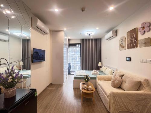 una sala de estar con un sofá y una cama en una habitación en Lily'house - Apartment Vinsmart City Tây Mỗ, en Kon Rung (1)